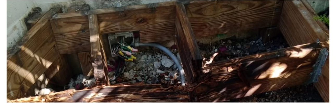 Rotted deck framing with exposed wiring before restoration